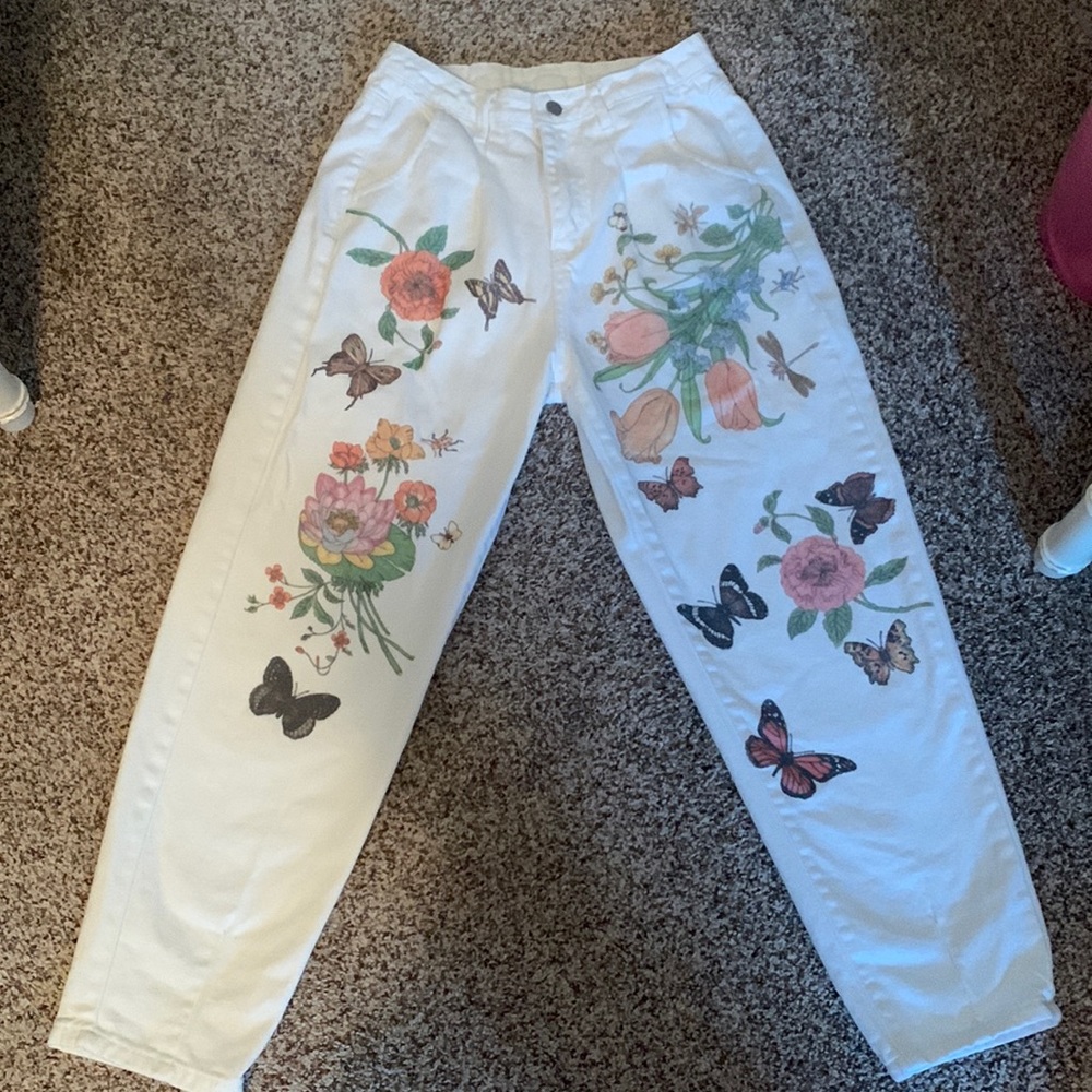 White jeans with butterfly and flower details.